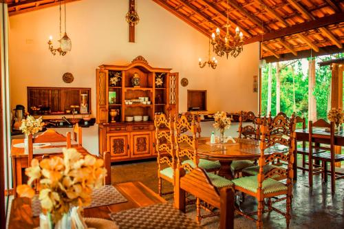 comedor con mesa y sillas en Pousada Rosa dos Ventos Capão en Vale do Capao