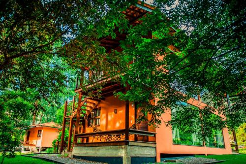 a building with a tree in front of it at Pousada Rosa dos Ventos Capão in Vale do Capao