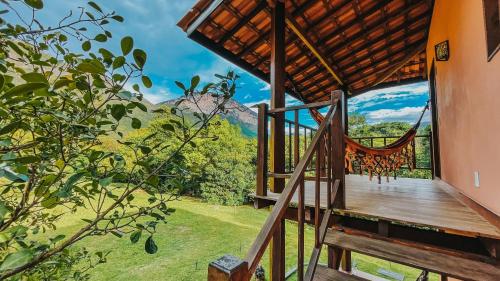 a porch of a house with a swing at Pousada Rosa dos Ventos Capão in Vale do Capao