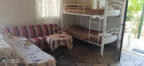 a living room with a couch and bunk beds at Cozy House in Samoutani in Vrachati