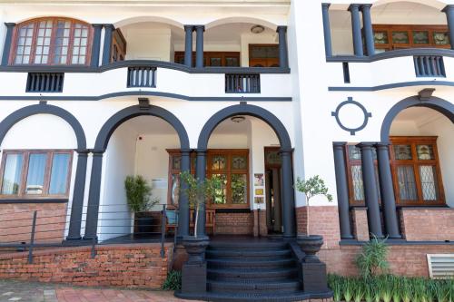 a house with arches and a staircase in front at Saint James on Venice in Durban