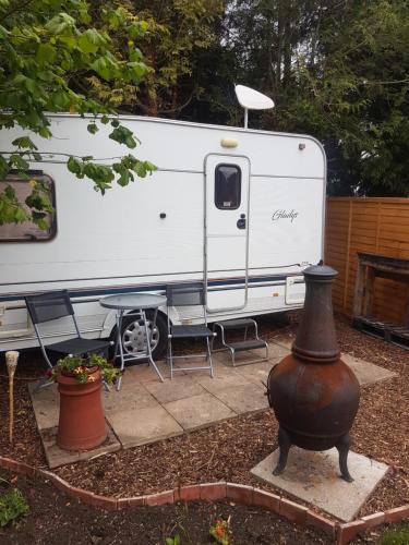 a white trailer parked in a yard with a fire hydrant at Maes Offa Stays in Llandysilio