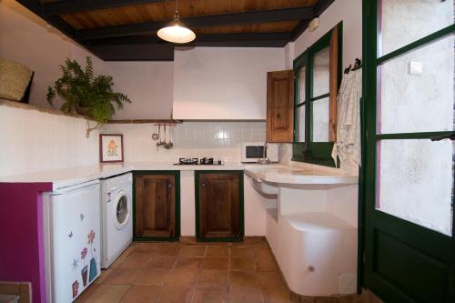 een keuken met een wastafel en een wasmachine bij LA CASETA DEL PRIORAT II in Porrera
