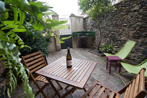 a bottle of wine sitting on a wooden table on a patio at LA CASETA DEL PRIORAT II in Porrera