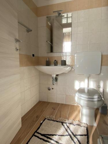 uma casa de banho com um WC branco e um lavatório. em Casa Sandrina em Caprino Veronese