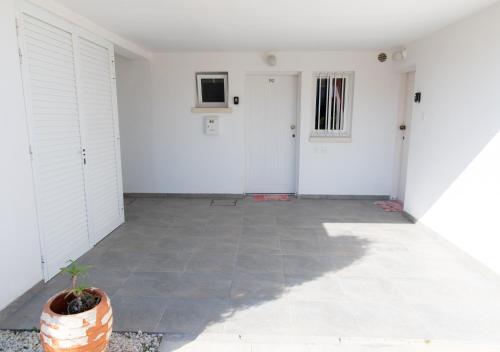 a hallway with white walls and a potted plant at Kypkeys Apartments in Voroklini