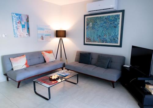 a living room with two couches and a coffee table at Kypkeys Apartments in Voroklini