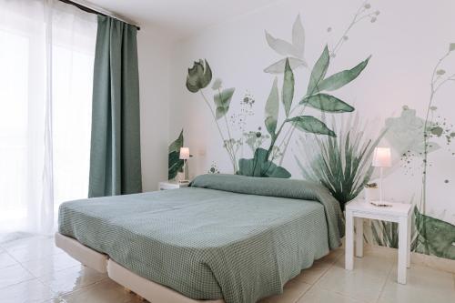 a bedroom with a bed with plants on the wall at Lamare cucina e dimore in Polignano a Mare
