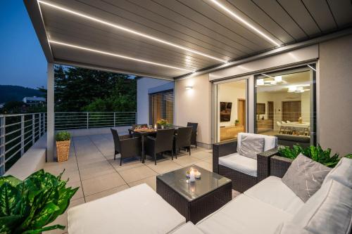 a patio with a white couch and a table at Apartmány Kaskády Luhačovice in Luhačovice