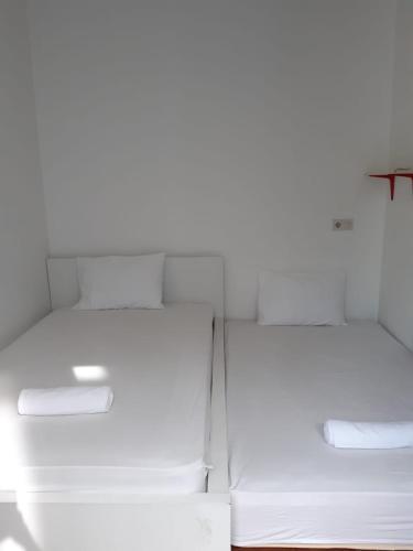 a white refrigerator with two beds in a room at 9AM in Tangerang