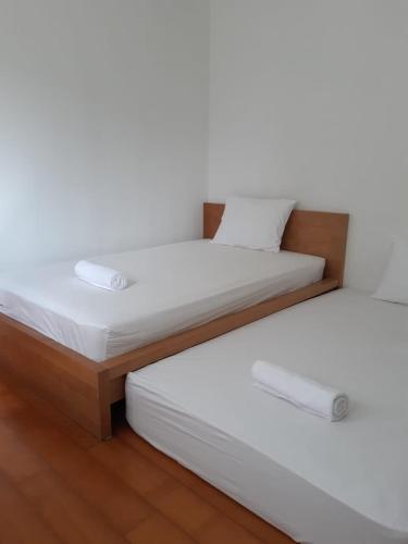 duas camas sentadas uma ao lado da outra num quarto em 9AM em Tangerang