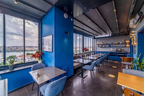 a restaurant with blue walls and tables and chairs at Galata Times Hotel in Istanbul