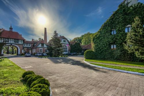 a cobblestone street in front of a building at Kadyny Folwark Hotel & SPA in Kadyny