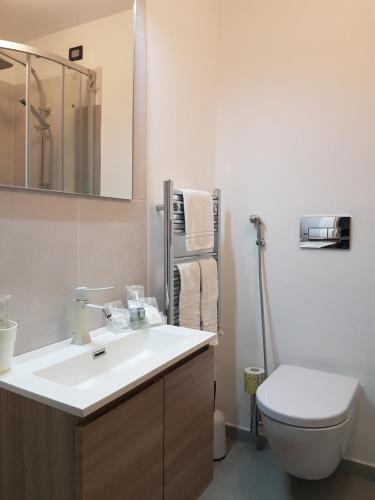 a bathroom with a white sink and a toilet at Villa Glamour in Taormina