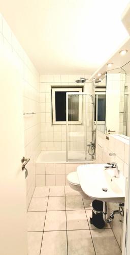 a white bathroom with a sink and a tub at Sanosueno 4 in Sonthofen