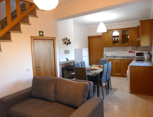 a living room and kitchen with a couch and a table at Casa e piscina privada in Fundão