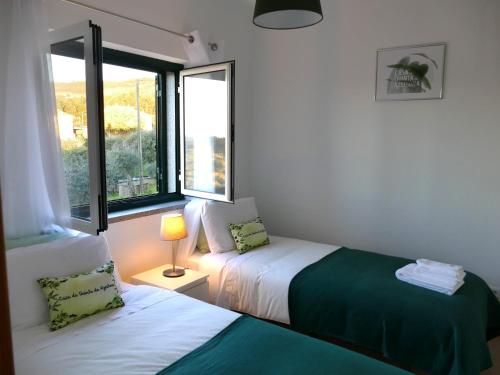 豐當的住宿－Casa e piscina privada，一间卧室设有两张床和窗户。