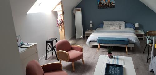 a bedroom with a bed and two chairs and a table at Au plaisir d’accueillir in Baden