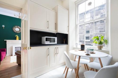 a small kitchen with a table and a microwave at Stockbridge Two Bedroom Apartment in Edinburgh