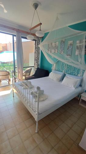 a bedroom with a white bed with a canopy at Art Studios Benitses in Benitses