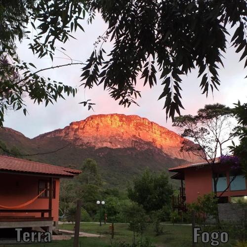 a view of a mountain with the sun setting on it at Pousada Rosa dos Ventos Capão in Vale do Capao