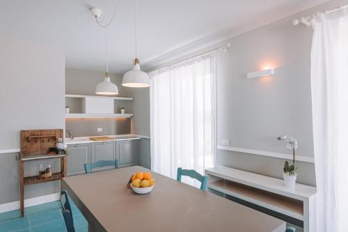 uma cozinha com uma mesa com uma tigela de laranjas em Lamare cucina e dimore em Polignano a Mare