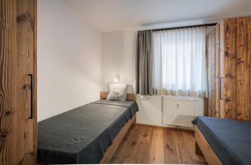 a bedroom with two beds and a window at Alpine Lodge by Apartment Managers in Kirchberg in Tirol