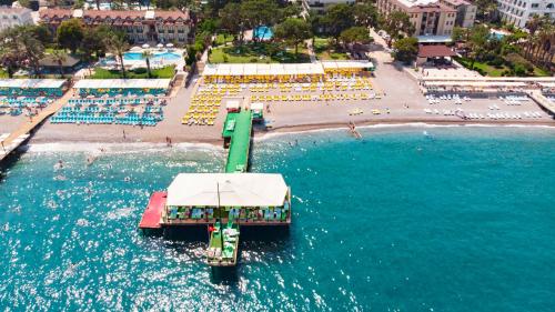 a pier in the water next to a beach at Dosinia Luxury Resort-Ultra All Inclusive in Beldibi