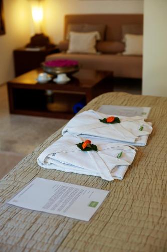a group of towels sitting on top of a bed at Shreyas Retreat in Nelamangala