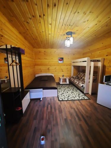 チェマルにあるДача Удачаの木造キャビン内の大型ベッド1台が備わる客室です。