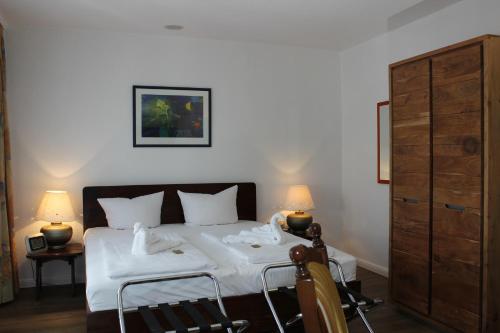 a bedroom with a bed with white sheets and two lamps at Aalto Hotel in Hannover