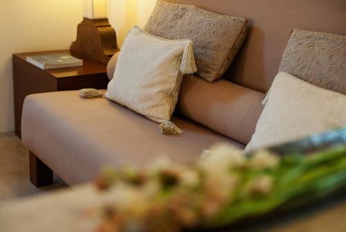 a couch with two pillows and a table with at Shreyas Retreat in Nelamangala