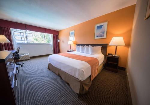 a hotel room with a large bed and a window at Howard Johnson by Wyndham Fullerton/Anaheim Conference Cntr in Fullerton