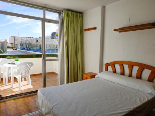 a bedroom with a bed and a balcony with a table and chairs at PeñiscolaPlaya Orangecosta in Peniscola