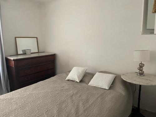 a bedroom with a bed with two pillows and a dresser at SOUS LE TILLEUL CENTENAIRE in La Tour-dʼAigues