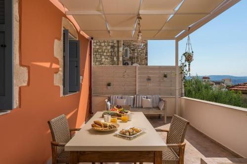 een patio met een tafel en stoelen op een balkon bij Iosif de Home in Kournás