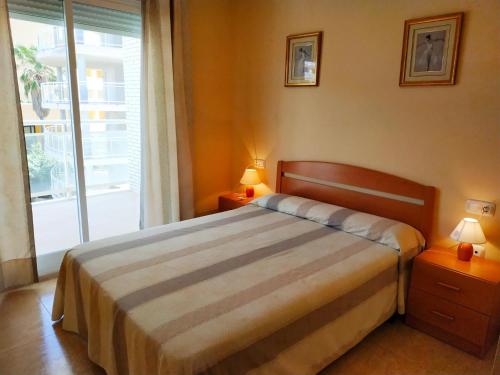 a bedroom with a bed and a large window at La Volta II Orangecosta in Peniscola