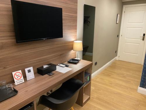 a room with a desk with a television on a wall at 7th Floor Suite in Naples