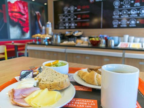 a table with two plates of food and a cup of coffee at ibis Calama in Calama