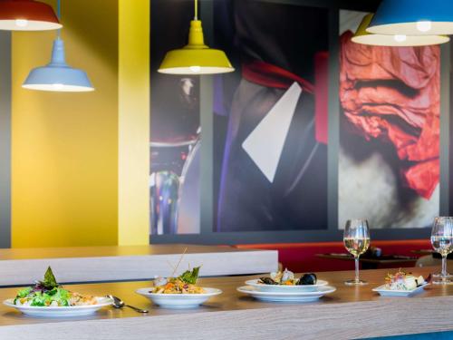 a table with plates of food and glasses of wine at ibis Calama in Calama