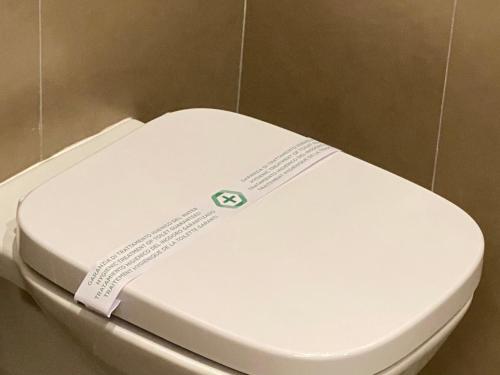 a white toilet seat with a label on it at 7th Floor Suite in Naples