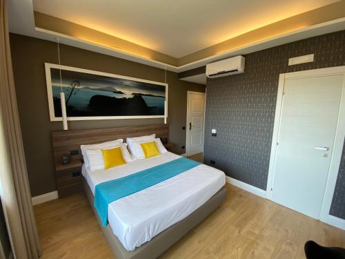 a bedroom with a large bed with yellow and blue pillows at 7th Floor Suite in Naples
