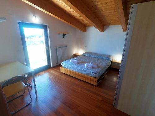 een slaapkamer met een bed, een tafel en een raam bij ATTICO con TERRAZZO, VIA DEL BORGO in Montesilvano