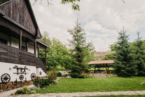 a house with a yard next to a building at Behív-Lak in Medişoru Mic