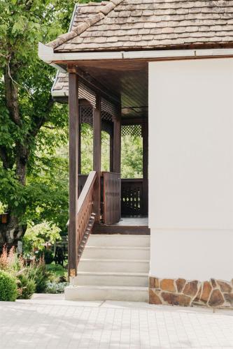 a wooden gazebo with a porch and stairs at Behív-Lak in Medişoru Mic