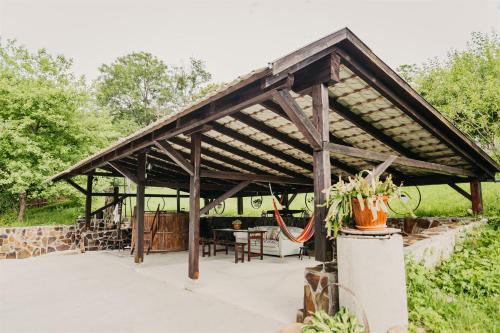 a wooden pavilion with a table and chairs at Behív-Lak in Medişoru Mic