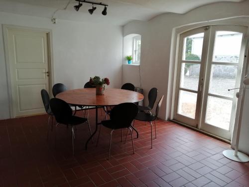 - une table et des chaises dans une chambre avec fenêtre dans l'établissement Shelter Slotsgaarden, à Jels