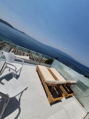 a patio with a table and chairs and the ocean at Hotel Aloha in Sarandë