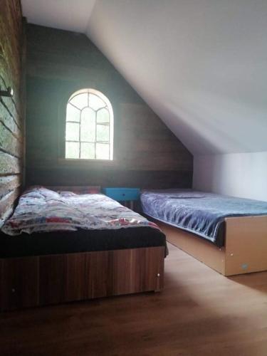 a bedroom with a bed and an attic window at Domek letniskowy TONKA in Świątki