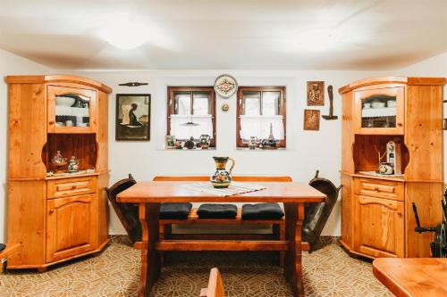 a dining room with a table and wooden cabinets at Behív-Lak in Medişoru Mic